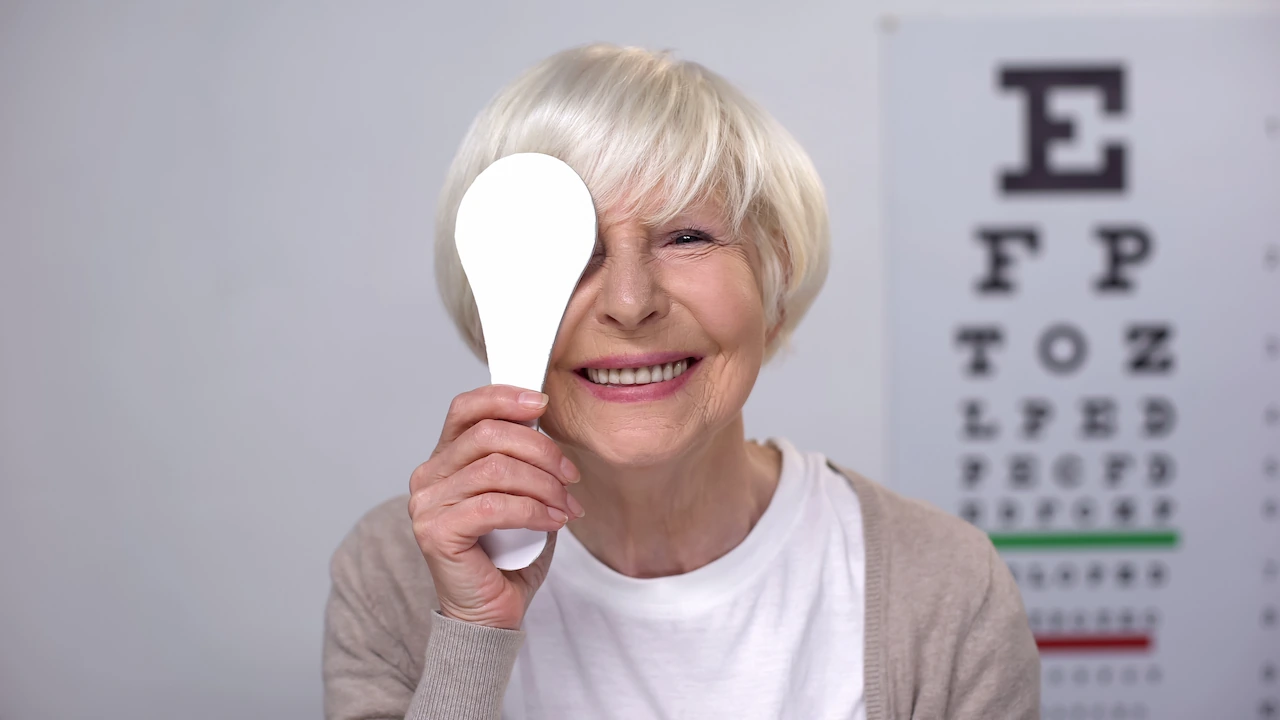 Elderly woman smiling during eye examination for cataract surgery and IOL options